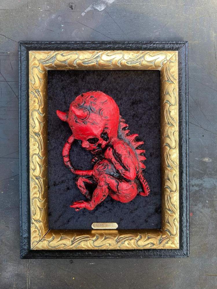 Blood red sculpture in a gold baroque frame
