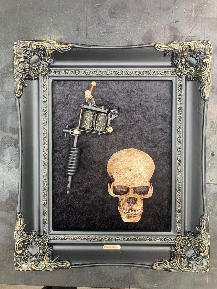 Gold skull and tattoo machine in a baroque frame